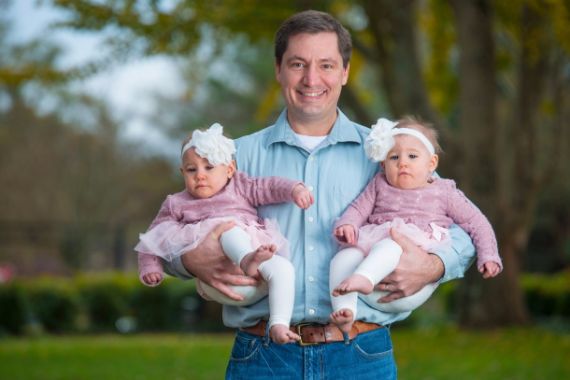 father holding baby daughters
